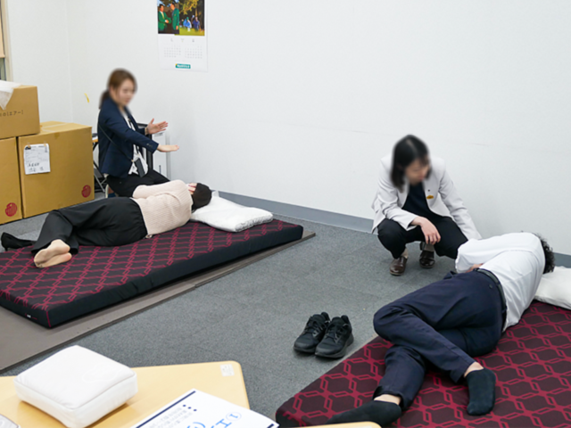 実際に枕を試す従業員たちの写真