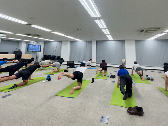 オフィスヨガを体験する従業員たちの写真