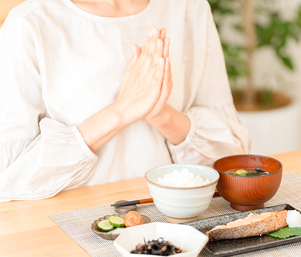 食卓で手を合わせる女性