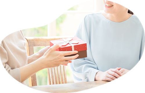 プレゼントを手に持つ女性とほほ笑む女性