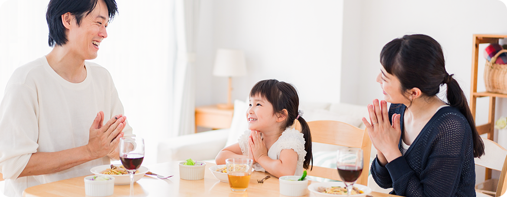 食卓で手を合わせる家族