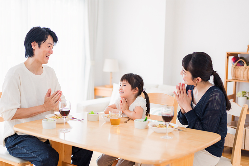 食卓で手を合わせる家族