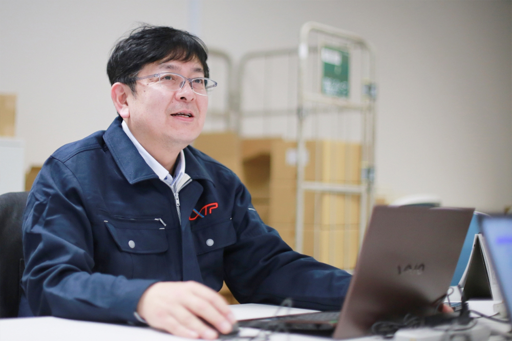事務所内で作業する佐藤さん