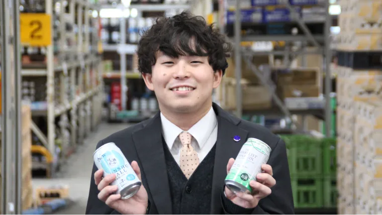 商品を手にした男性スタッフの笑顔の写真