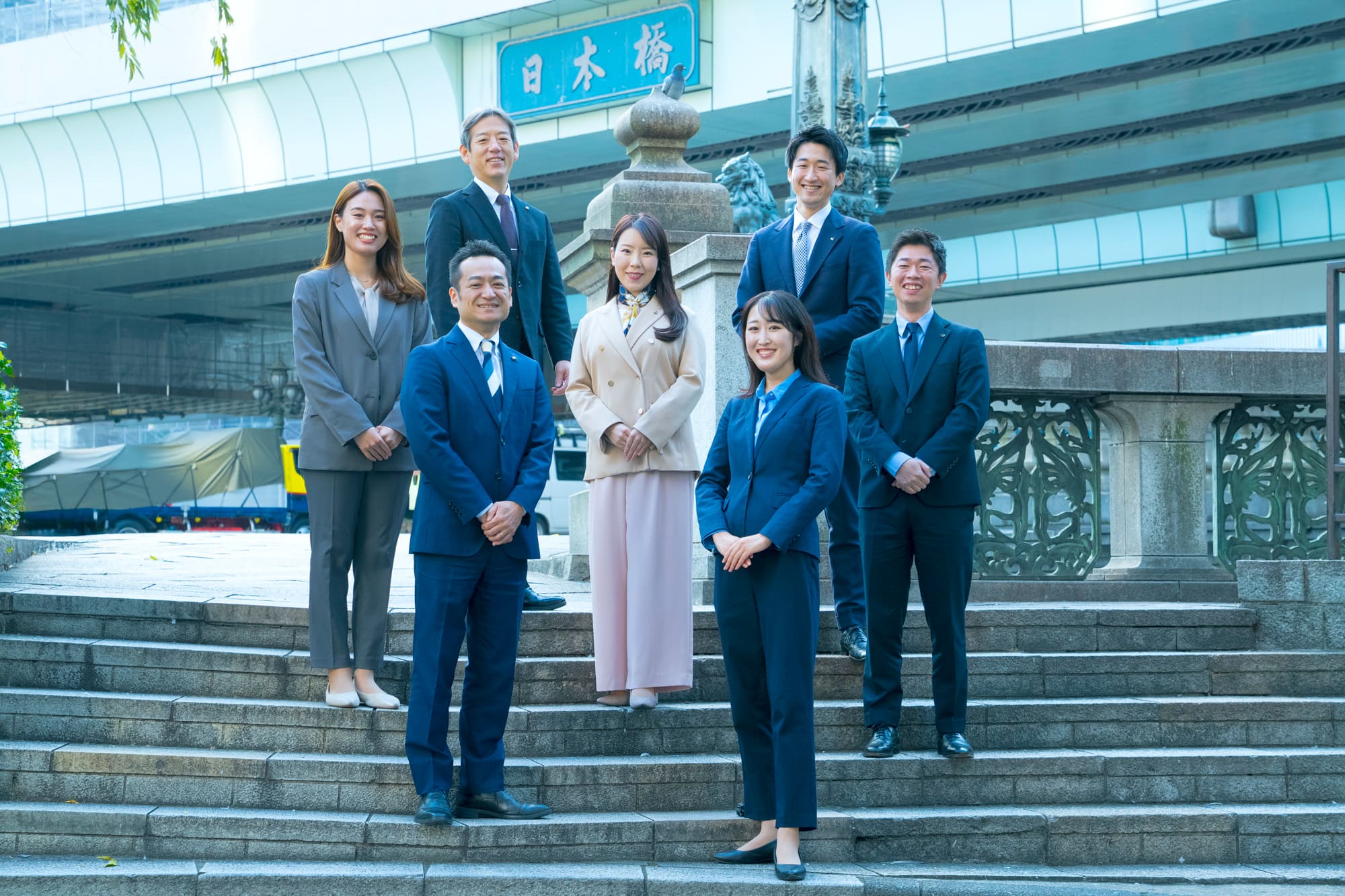 社員７名が日本橋の階段で立っている写真