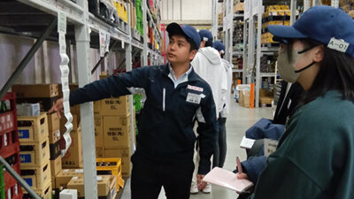 倉庫内での業務指導を行う男性社員の写真