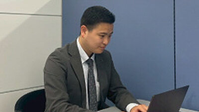 落ち着いた表情でパソコンを操作する男性社員の写真